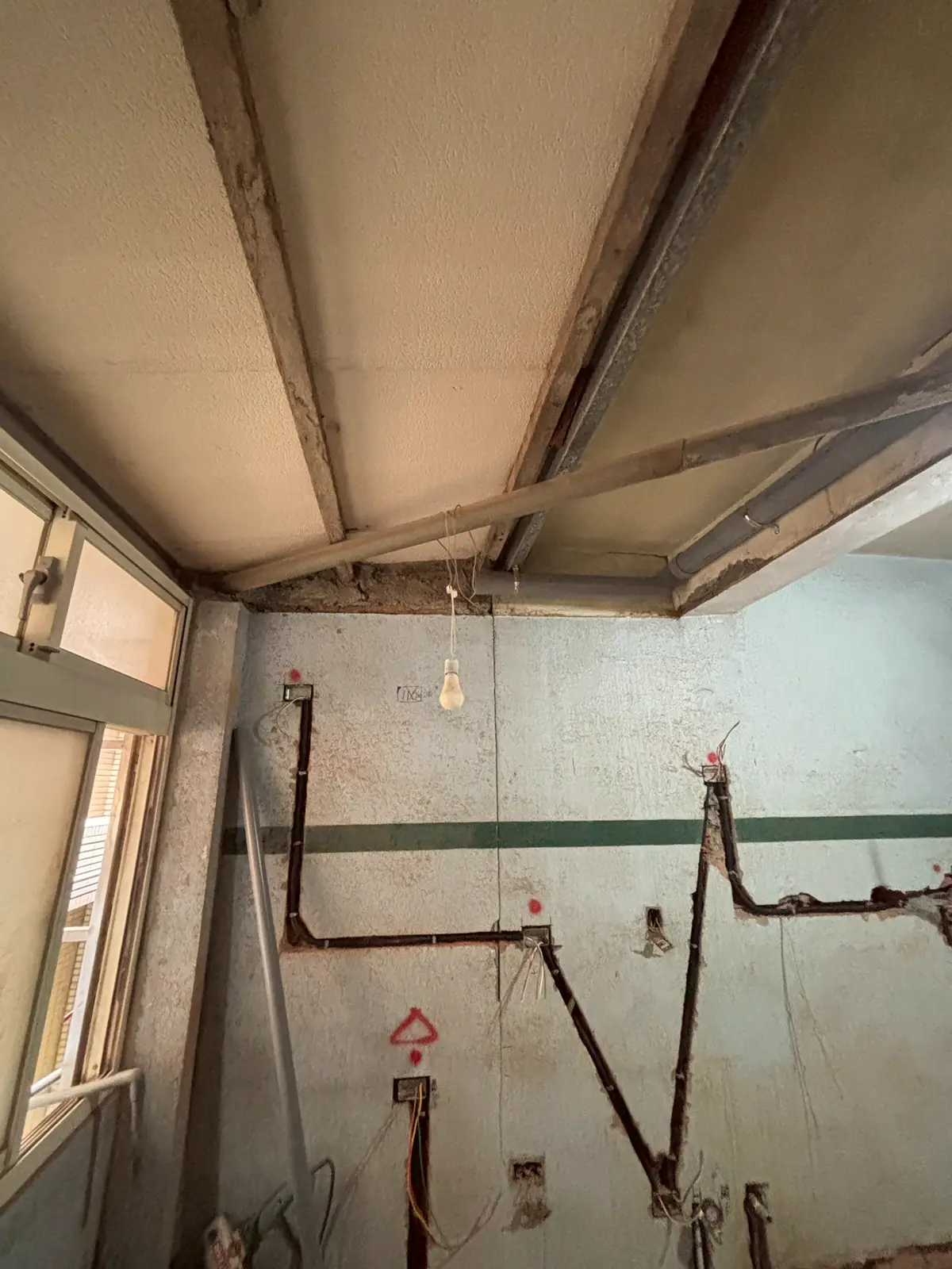 老屋牆面與天花交界處開槽配置電管的施工現場