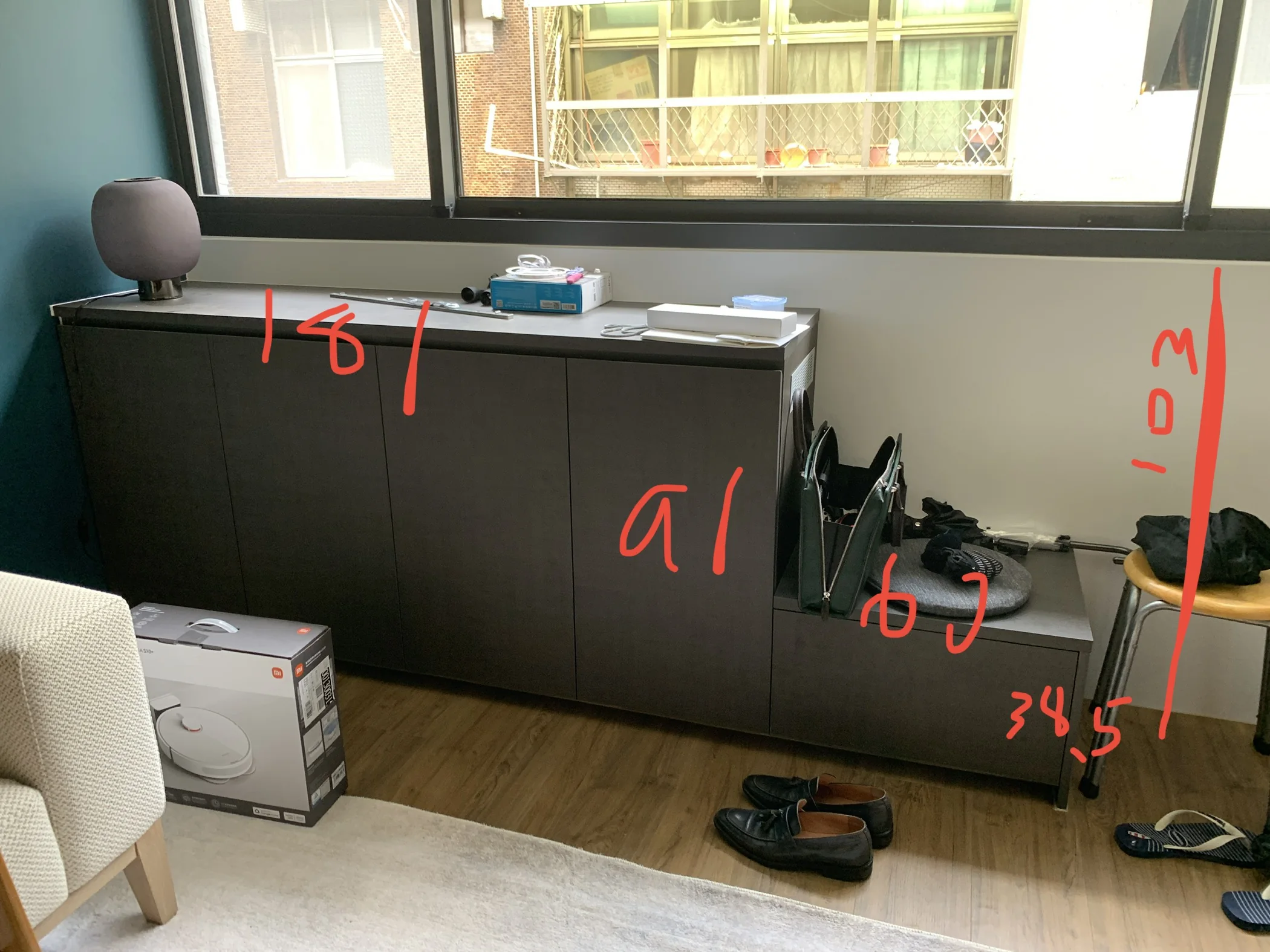客廳窗下深色矮櫃與家具尺寸的現場標註